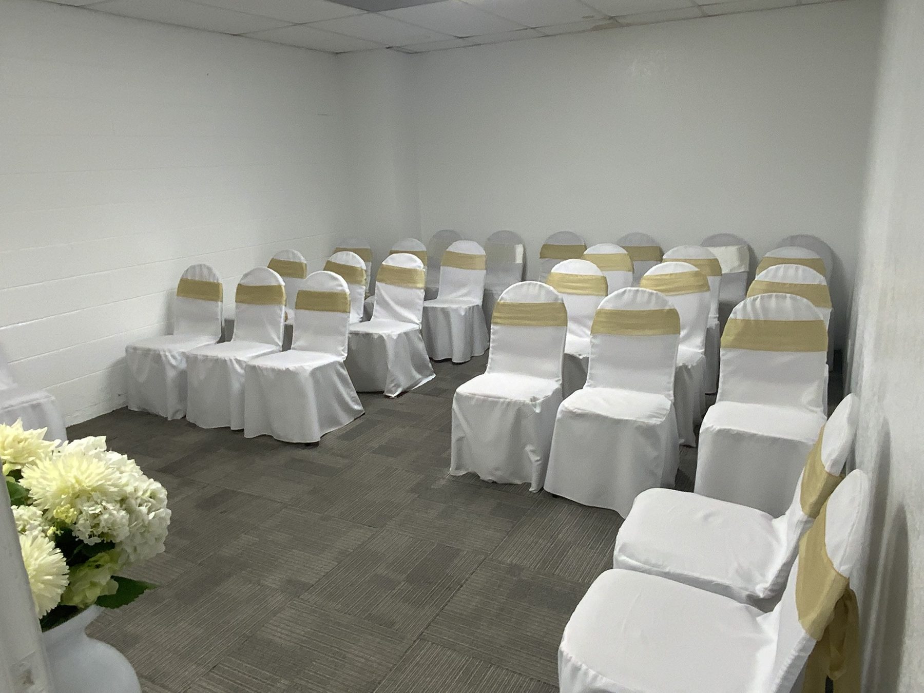 Chapel seating with white chair covers and gold accents